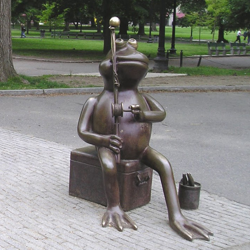 A sculpture of a humpbacked frog ponders in a park garden