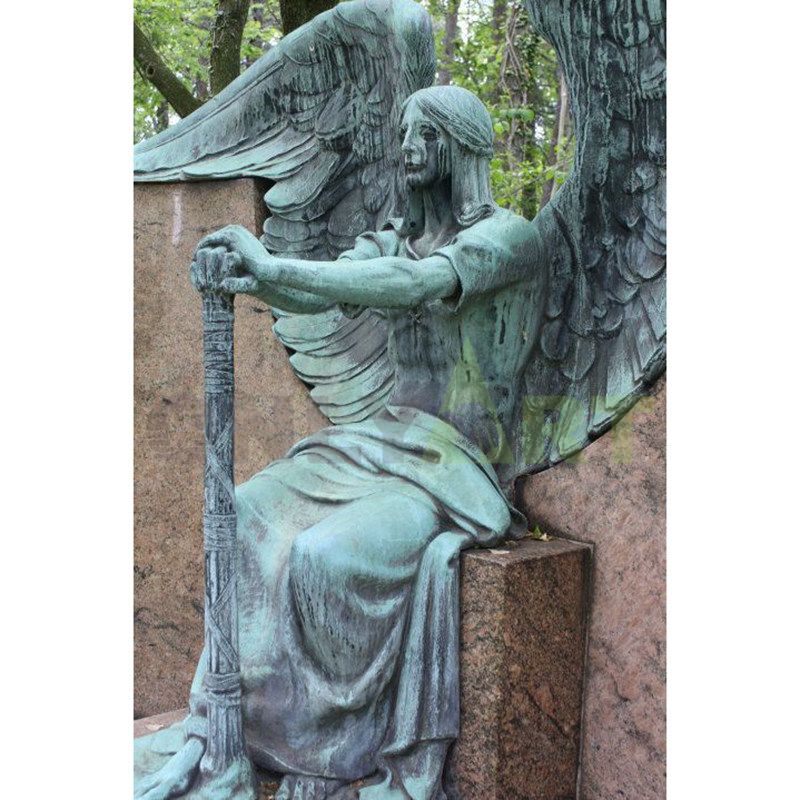 A bronze statue of a weeping angel holding a sword