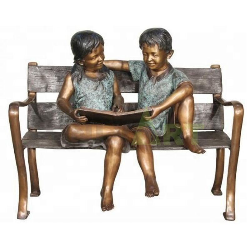 A sculpture of two children reading together on an apartment bench