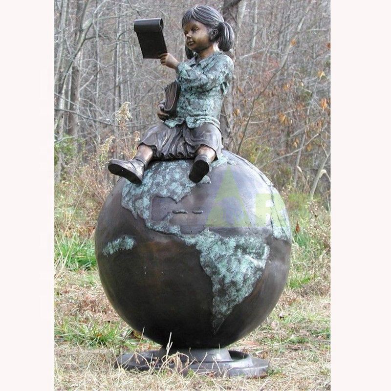 A little girl sitting on a globe