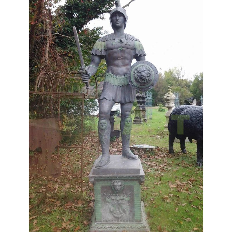 The Spartan leans over a heavily armed bronze statue