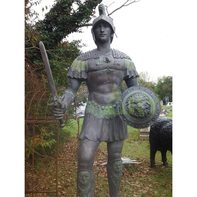 The Spartan leans over a heavily armed bronze statue