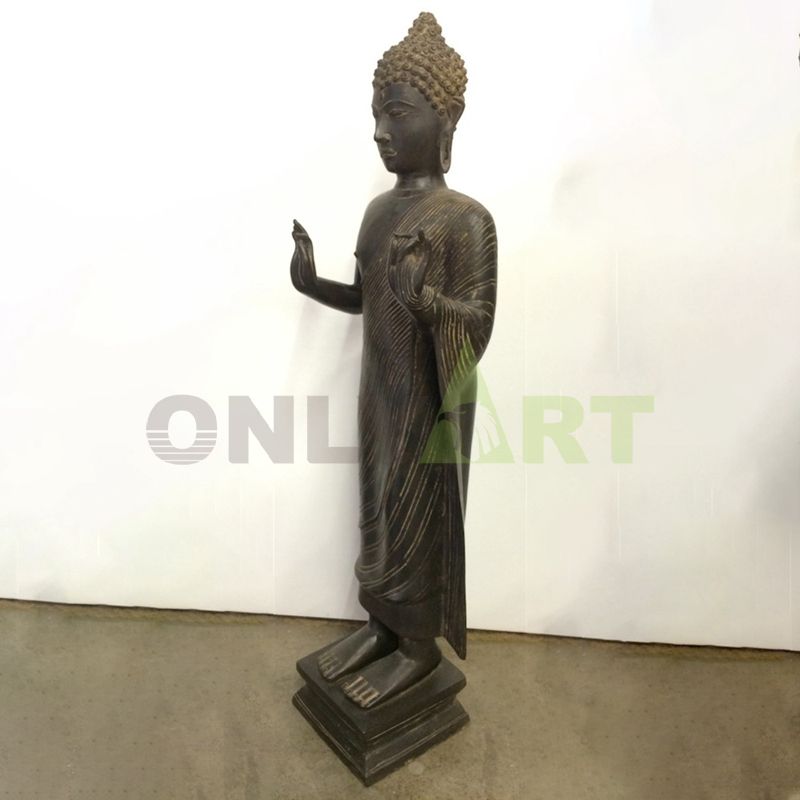 A bronze statue of a standing Buddha