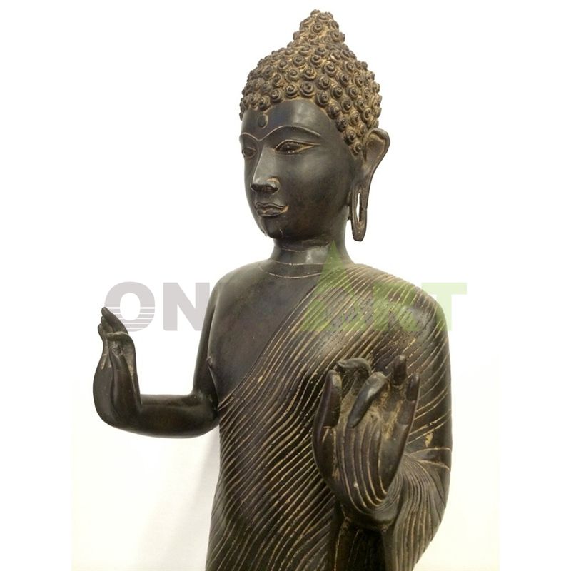 A bronze statue of a standing Buddha