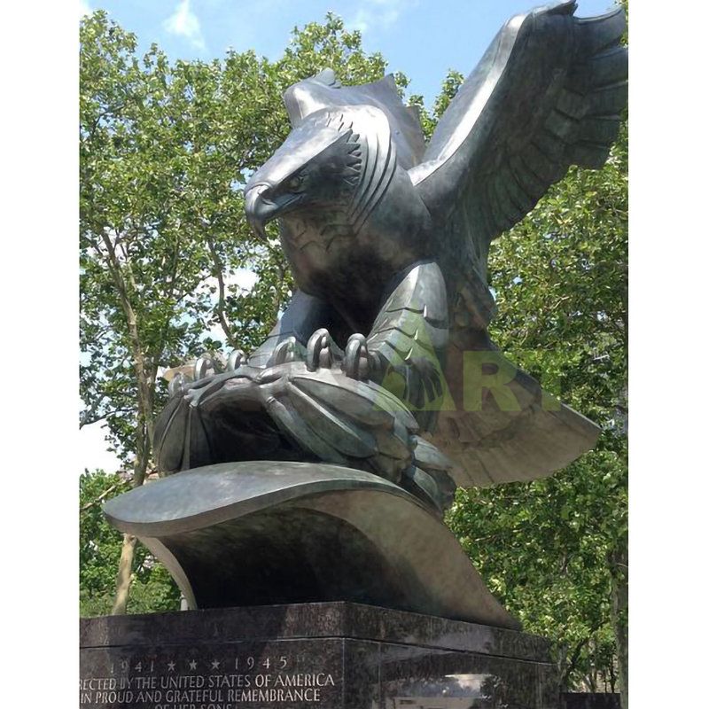 A bronze eagle with wings spread on a branch