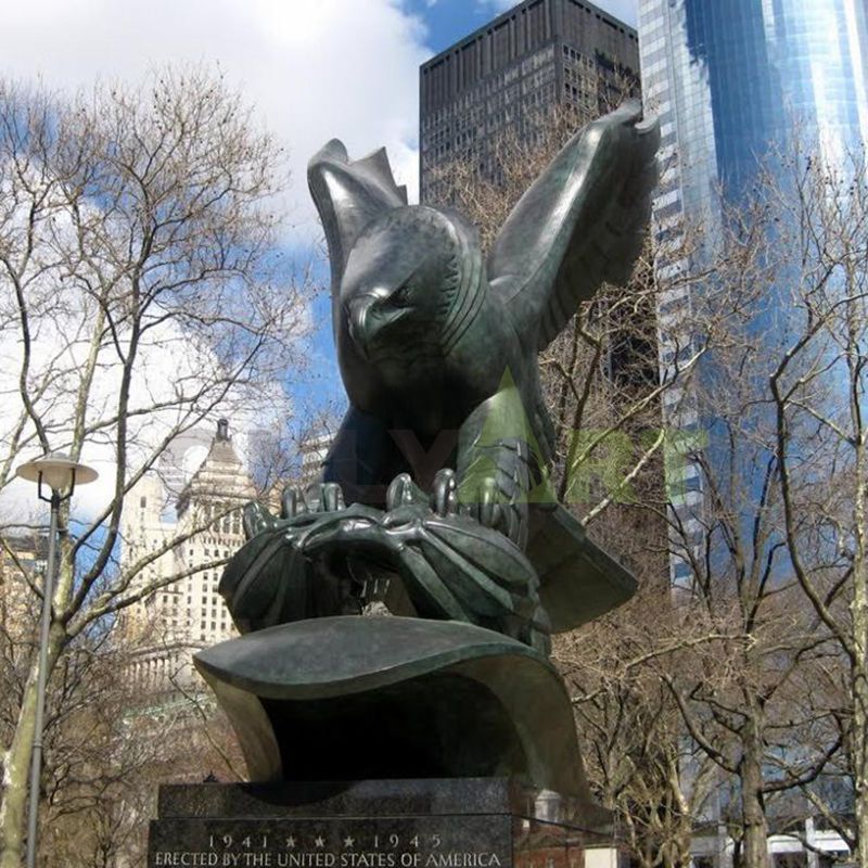 A bronze eagle with wings spread on a branch