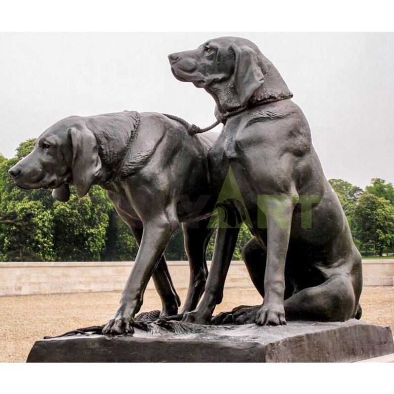 . Sculpture of two dogs on a leash in a park