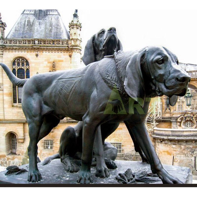 . Sculpture of two dogs on a leash in a park