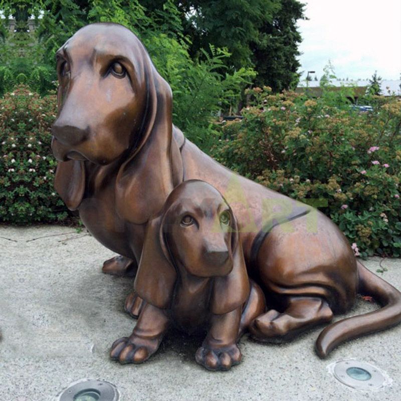 A bronze sculpture of a long-eared dog and her baby