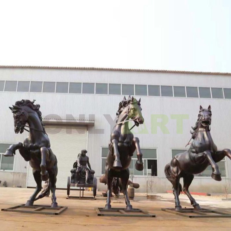 A bronze statue of three horses soaring into the air