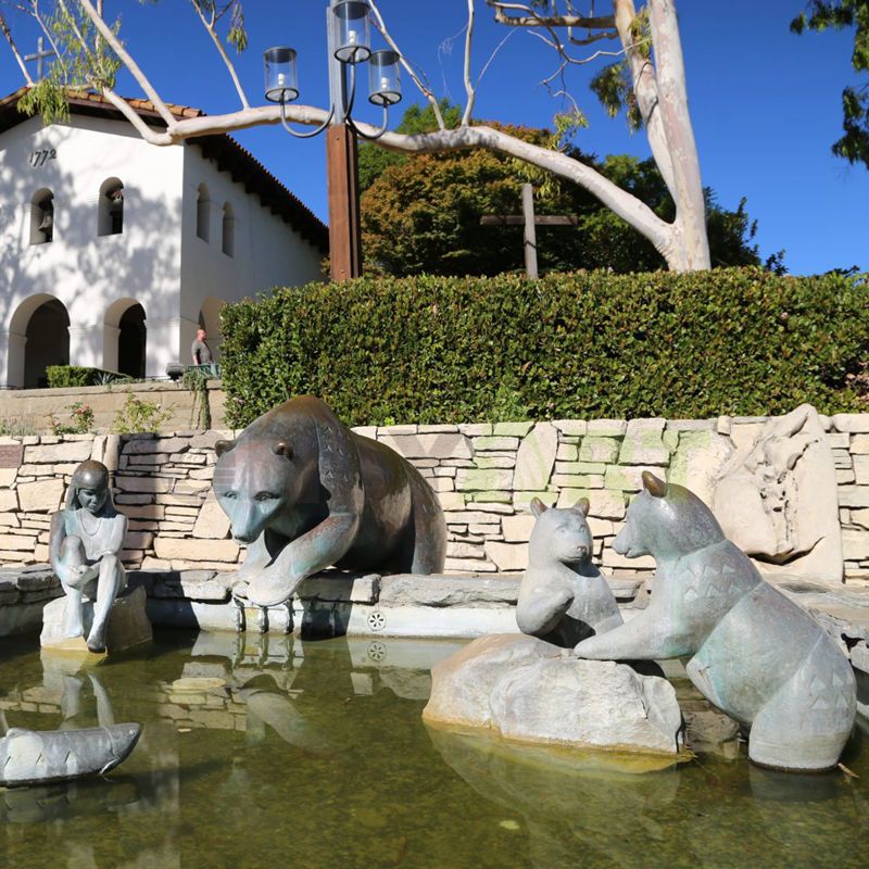 A bronze sculpture of a beautiful woman and a brown bear family