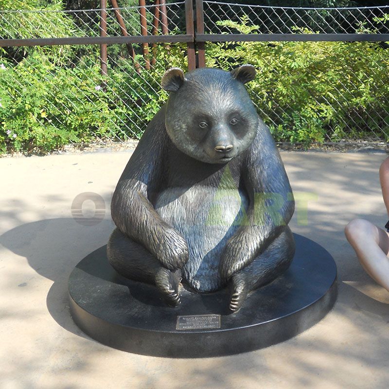 Bronze bear sculpture, panda holding a stone