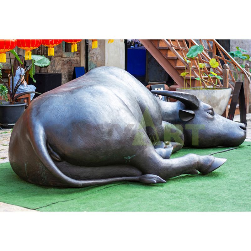 A life-size antique bronze statue of an outdoor bull and a standing naked man