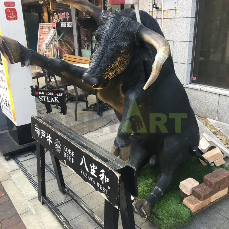 A sculpture of a beautiful woman and a bull wrapped around the back of an ox