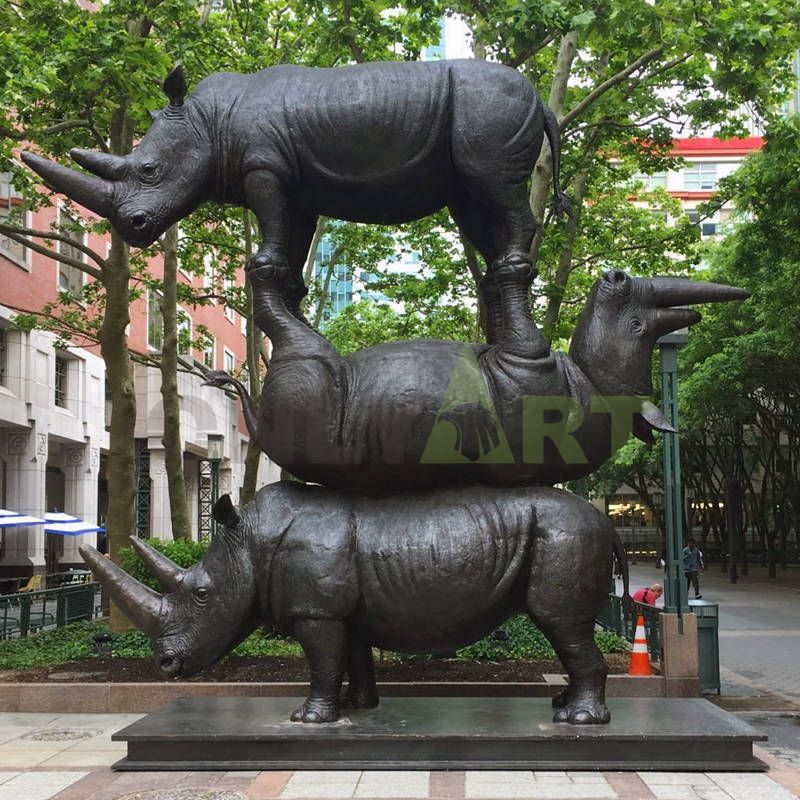 A sculpture of a rhinoceros beneath an animal couple