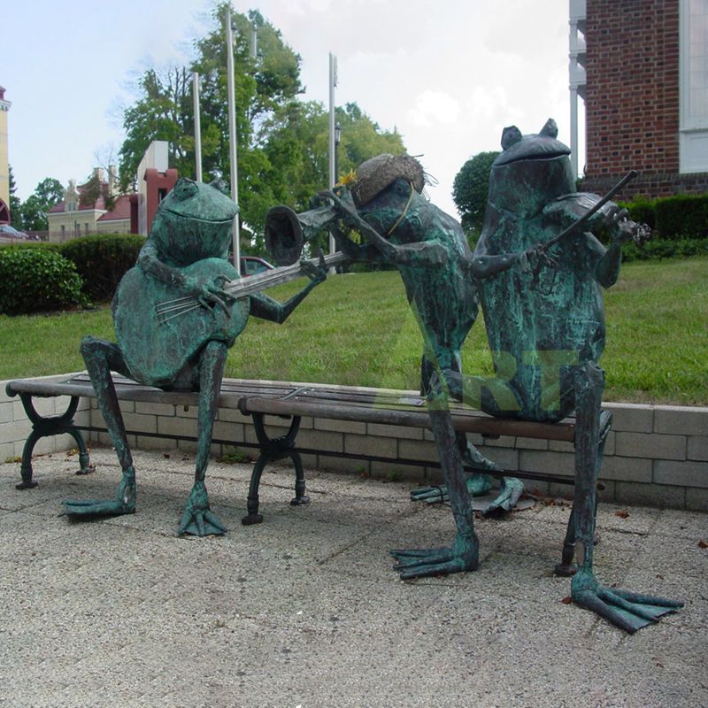 Sculpture of a frog sitting on a chair playing a violin