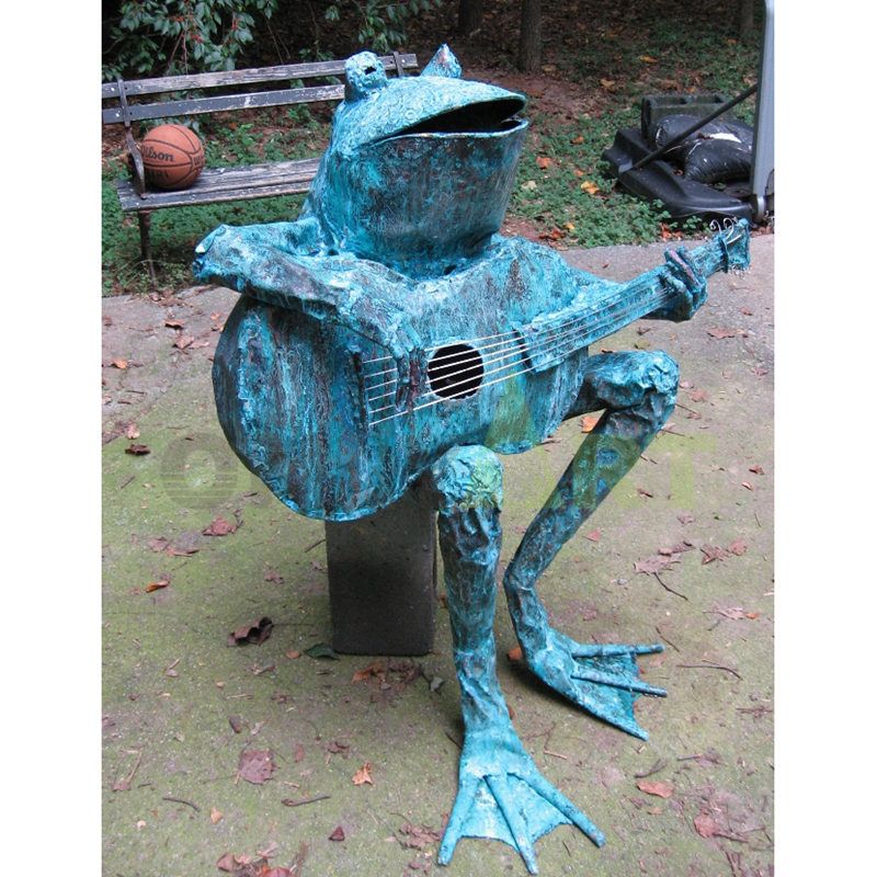 Sculpture of a frog sitting on a chair playing a violin