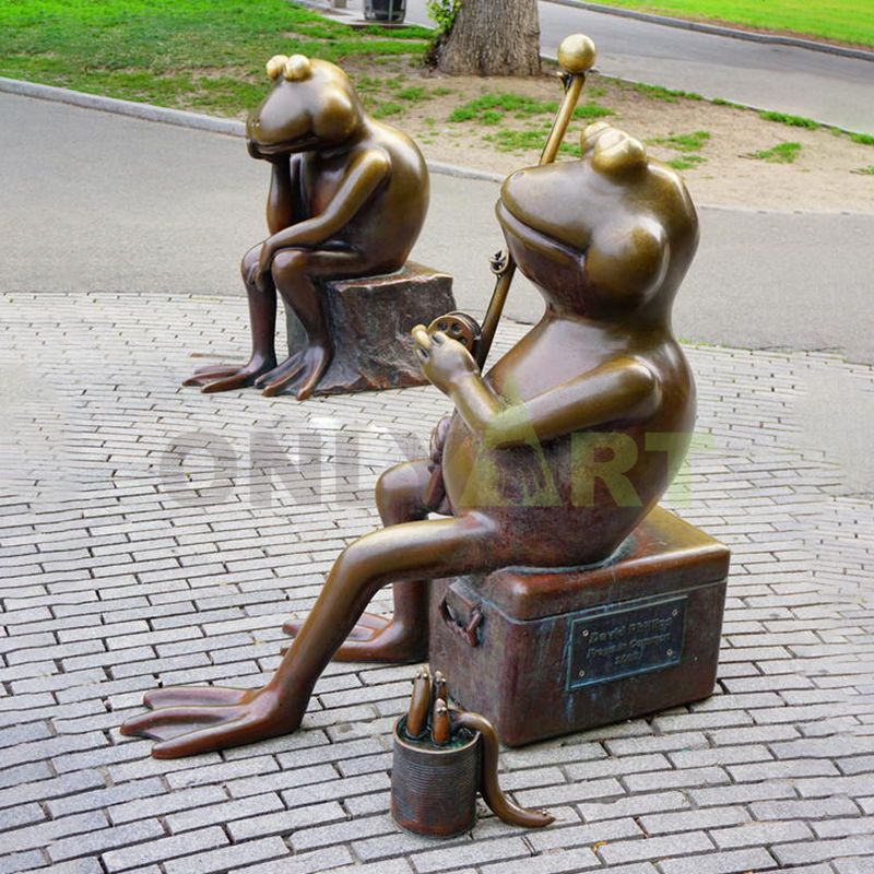 Sculpture of a frog sitting on a chair playing a violin