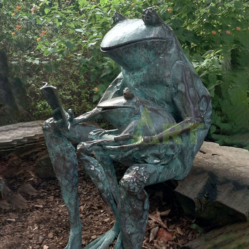 A bronze statue of a frog reading a book