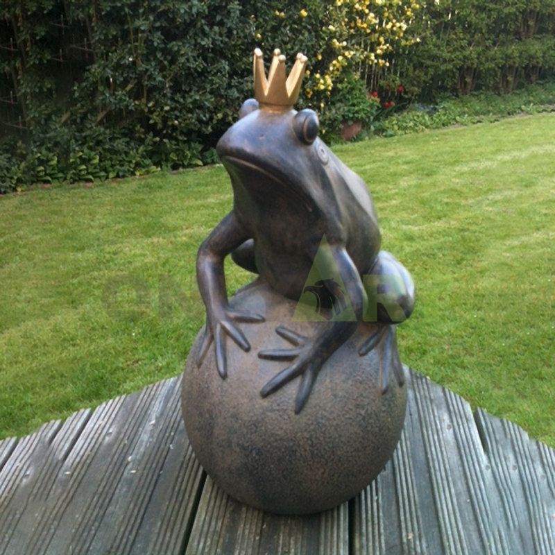 A bronze statue of a frog reading a book