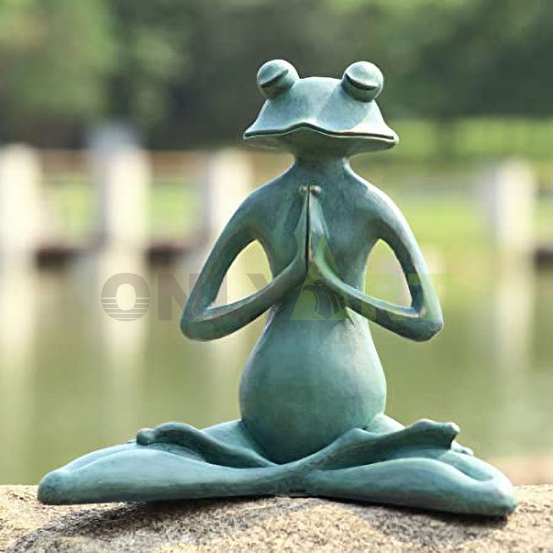 A bronze statue of a frog reading a book