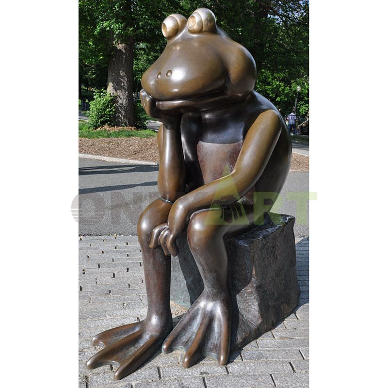 Realistic frog Prince Garden statue looking at the golden crown